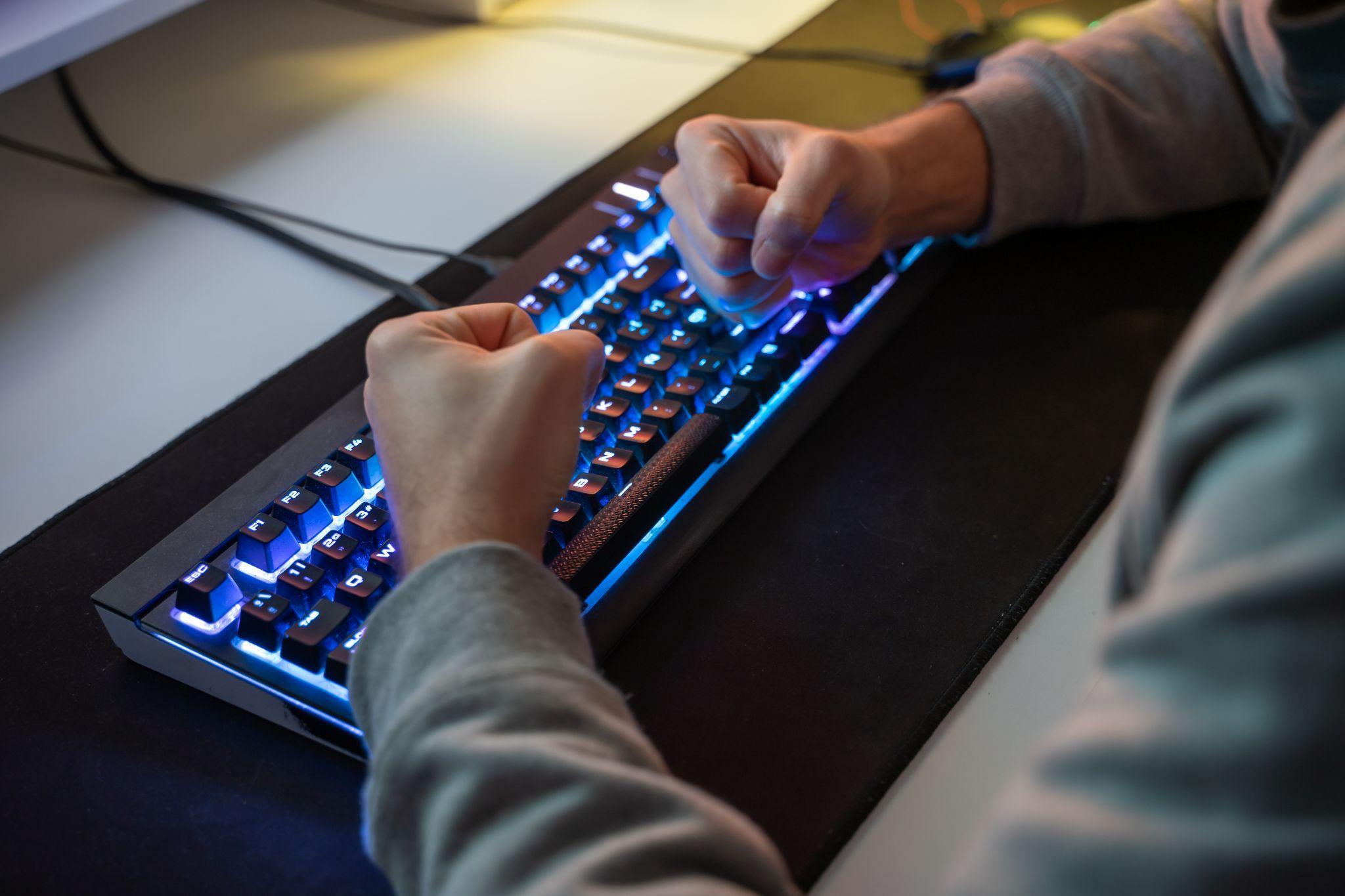 A sleek wireless mechanical keyboard on a wooden desk